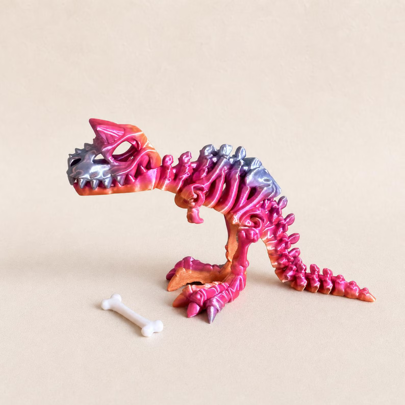 Colorful articulated Carnotaurus toy with a separate white bone accessory